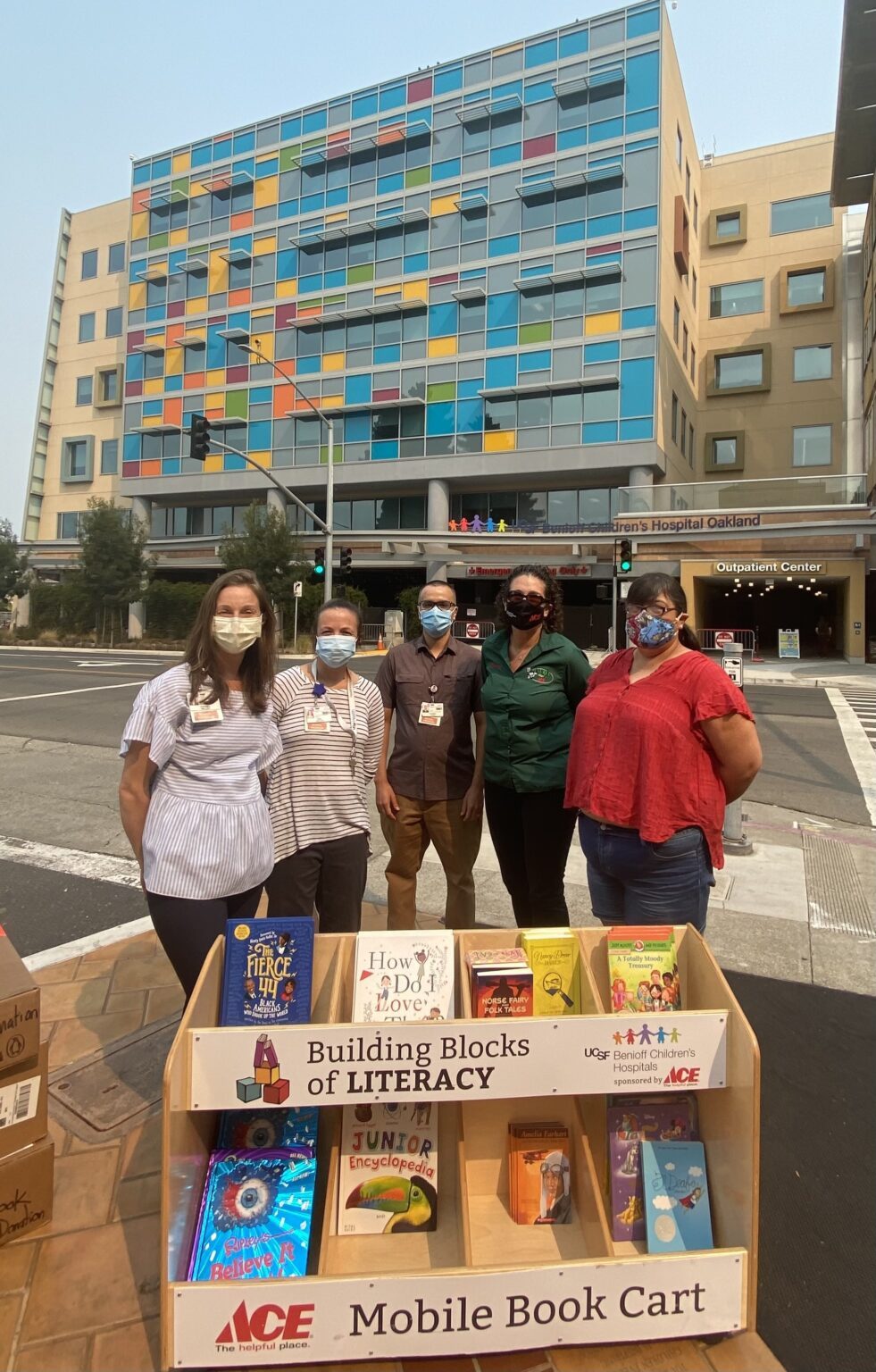 Staff with a mobile book cart of donated books
